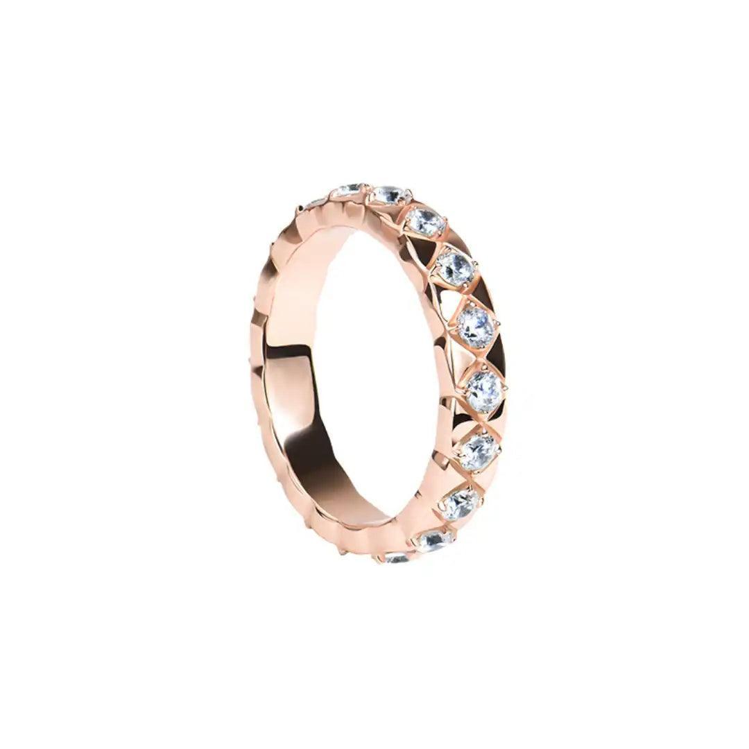 A close-up image of the Mozi Blush Brilliance Ring, showcasing its Rose Gold-plated band with VVS1 Moissanite stones set in a unique geometric pattern.