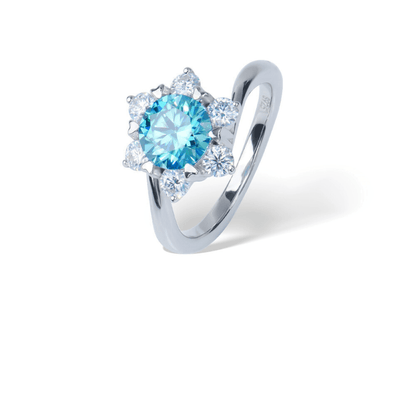 Blue Snowflake Moissanite Ring, featuring a round blue Moissanite surrounded by sparkling accents set in sterling silver, displayed on a white background.