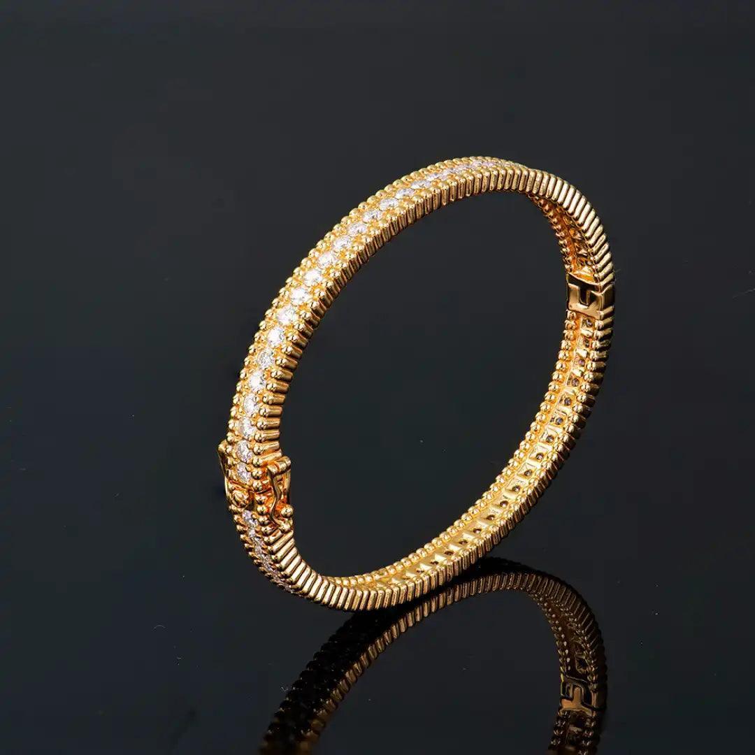 Mozi Celestial Gold Moissanite Bangle displayed on a black reflective surface, highlighting its intricate gold detailing and the brilliance of the moissanite stones