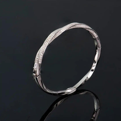 Mozi Mobius Moissanite Bangle displayed on a dark background, highlighting its S925 silver Mobius twist design with sparkling moissanite stones