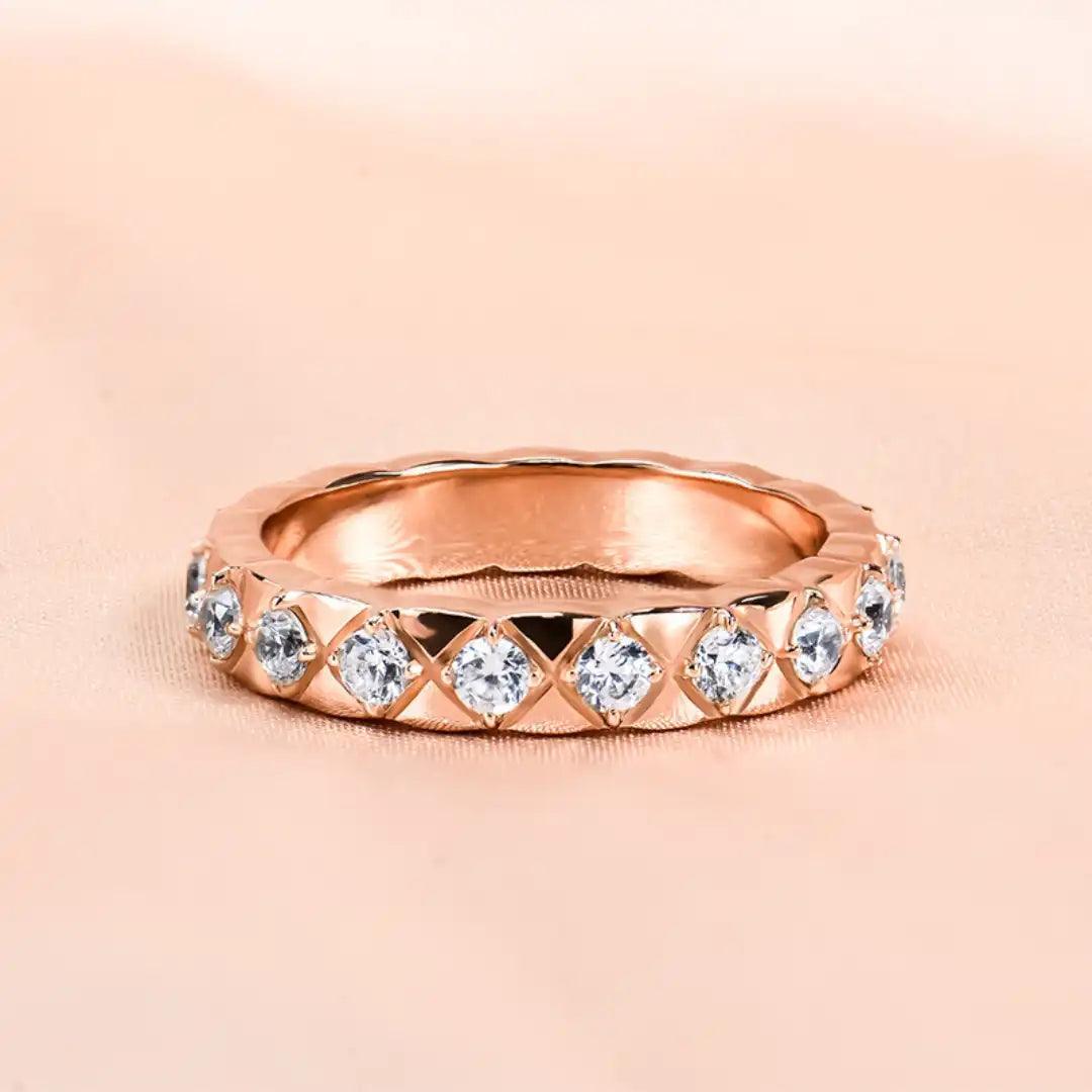 The Mozi Blush Brilliance Ring displayed against a soft pink background, highlighting its shimmering Moissanite stones and Rose Gold finish.