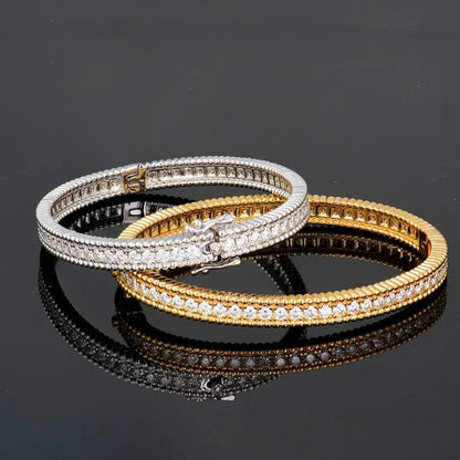 Mozi Celestial Moissanite Bangles in gold and silver, elegantly stacked together with their sparkling moissanite stones reflecting on a glossy black surface