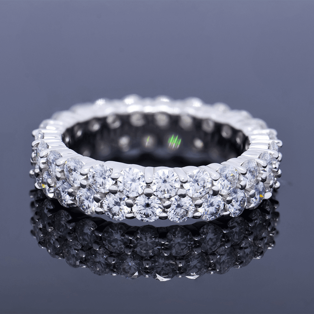 Double Sparkle Moissanite Tennis Ring placed on a reflective surface, emphasizing its brilliance and elegance