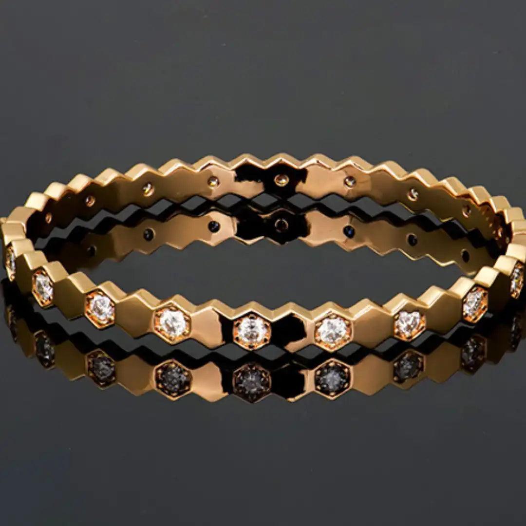 Mozi Beehive Moissanite Bangle displayed on a reflective black surface, featuring a hexagonal gold design with moissanite stones