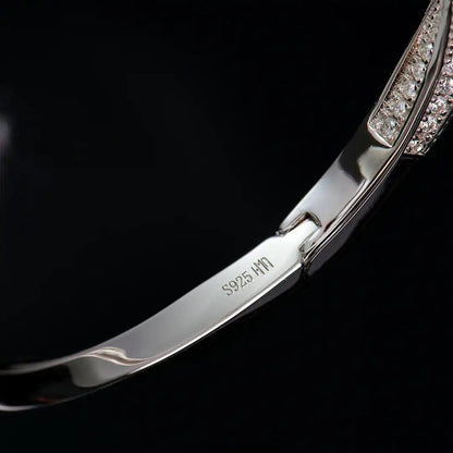 Close-up of the Mozi Mobius Moissanite Bangle showing the S925 silver hallmark and moissanite stone details against a dark background