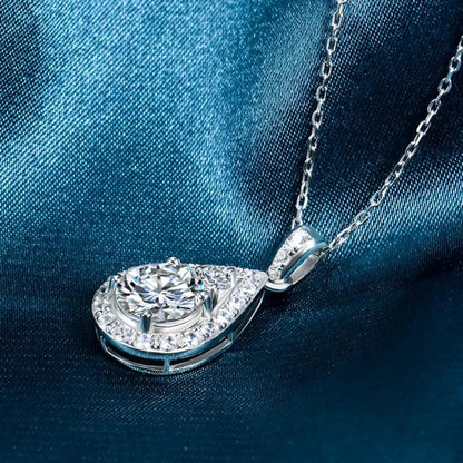 Full view of the Teardrop Moissanite Necklace, with the pendant displayed on a satin teal fabric, showcasing its elegance and luxury.