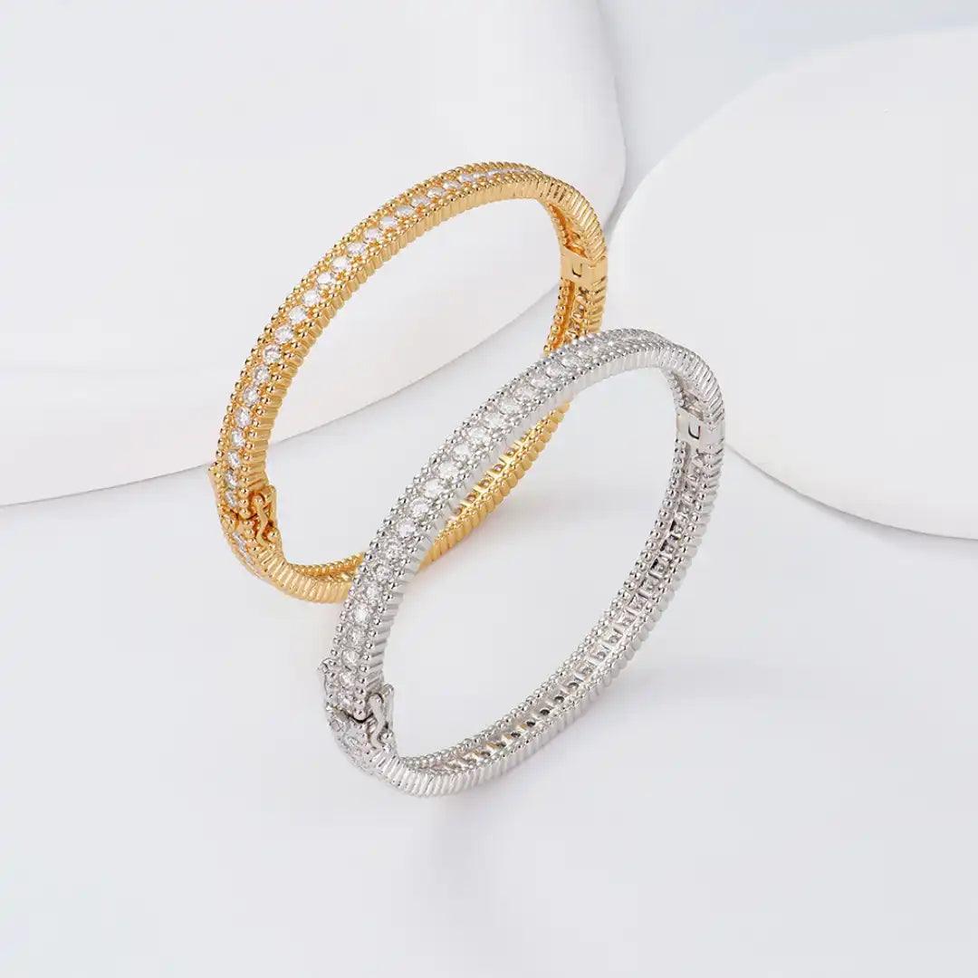 Mozi Celestial Moissanite Bangles in gold and silver, elegantly placed on a white surface, highlighting the sparkling moissanite stones and the intricate design of each bangle