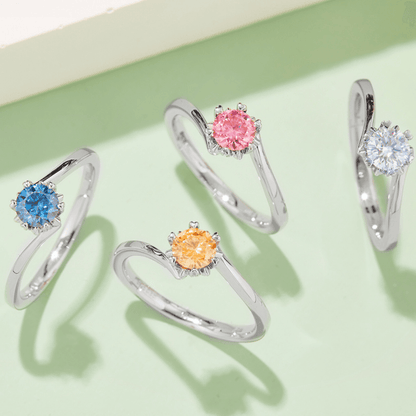 Four Blue Flower Moissanite Rings in different colors, displayed in a row on a light green background.