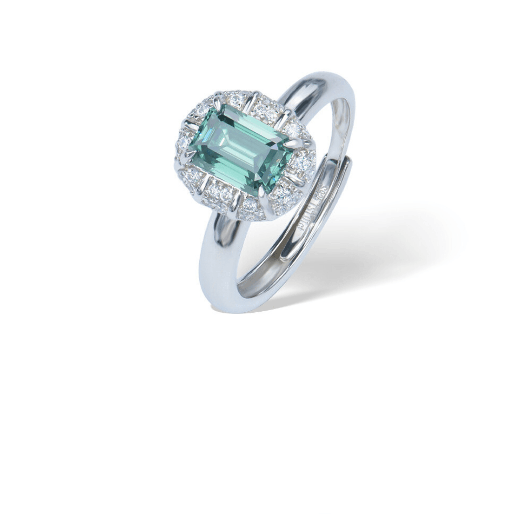 Emerald Adjustable Ring from the Sparkle Collection, featuring an emerald-cut green Moissanite surrounded by sparkling accents, displayed on a white background.